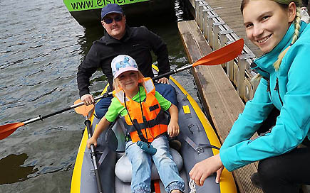 Erzieherschülerin der DPFA Leipzig lässt ein Kanu mit einem Kind und seinem Vater zu Wasser.