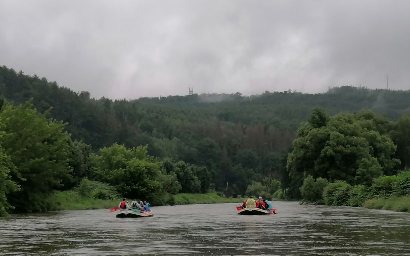 Zwei Schlauchboote fahren auf einem Fluss.