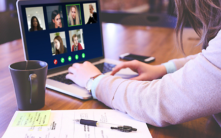 Beispielspiel einer Videokonferenz wie sie bei der DPFA abgehalten wurde: Eine junge Frau sitzt vor ihrem Laptop während einer Videokonferenz.
