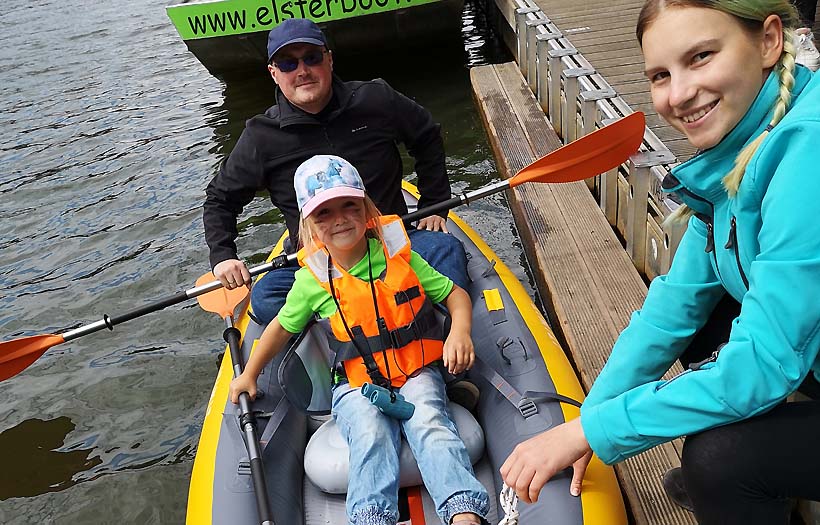 Erzieherschülerin der DPFA Leipzig hilft Kita-Vater und dessen Tochter beim Einstiegt ins Schlauchpaddelboot auf dem Leipziger Elsterflutbecken.