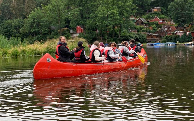 Die Schülerinnen und Schüler der Klasse E21C der Erzieherausbildung der DPFA Chemitz paddeln in einem Kanu.