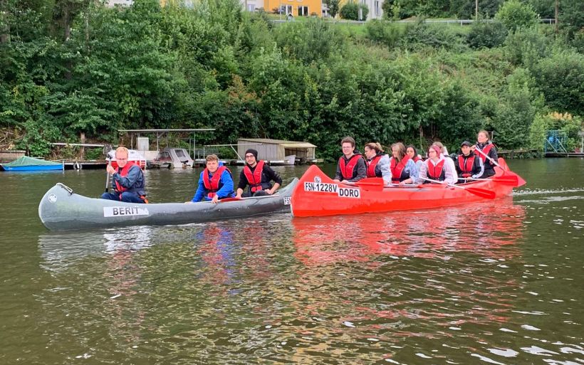Die Schülerinnen und Schüler der Klasse E21C der Erzieherausbildung der DPFA Chemitz paddeln in einem Kanu. Zu sehen sind nun zwei Boote.