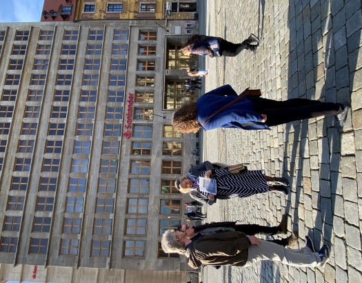 Auf dem Marktplatz der Stadt Breslau gibt eine Dame den deutschen Schülern und Schülerinnen eine Stadtführung.