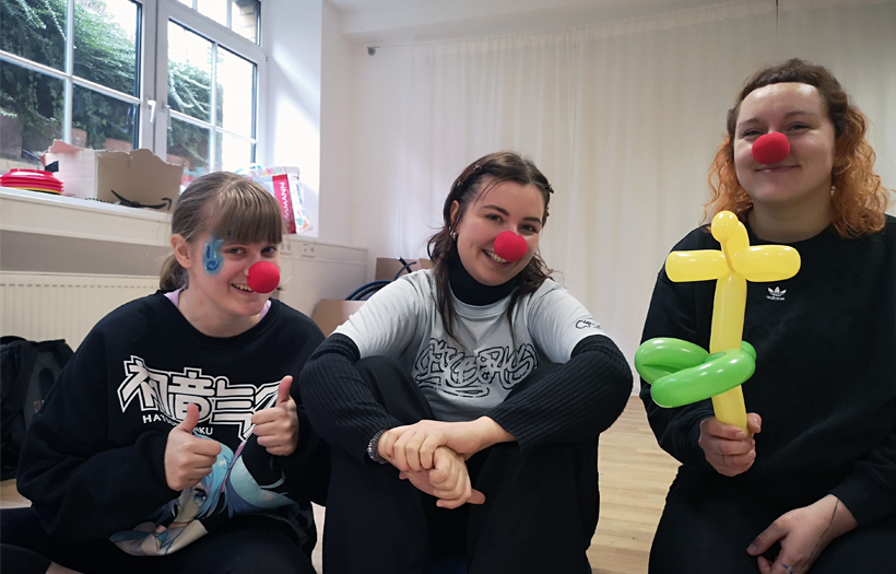 Drei Frauen posieren mit roten Clownsnasen für ein Foto.